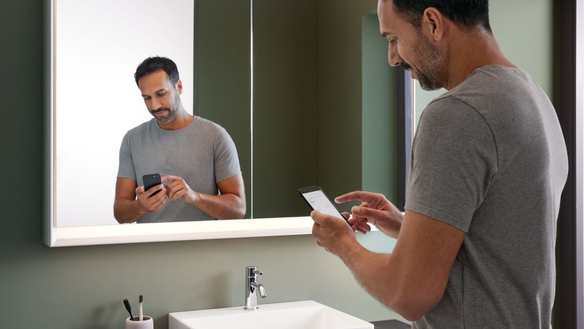 Man standing in the bathroom with a mobile phone