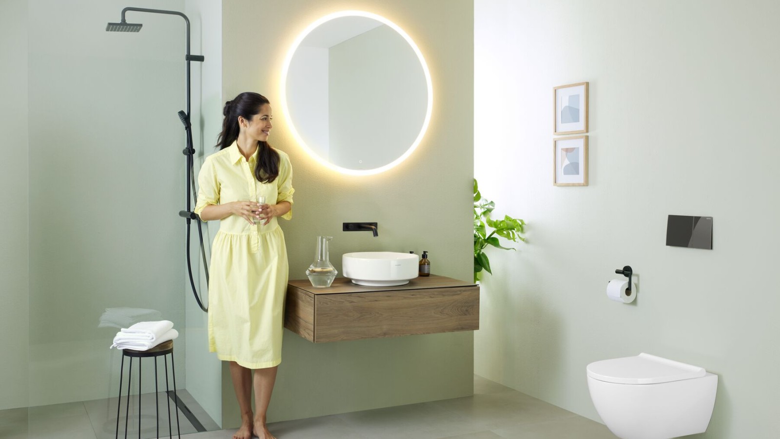 Woman in bathroom featuring a Geberit Option mirror and Geberit VariForm washbasin
