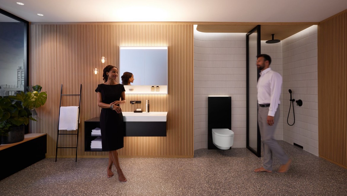 Man and woman in perfectly lit bathroom with Geberit ONE products
