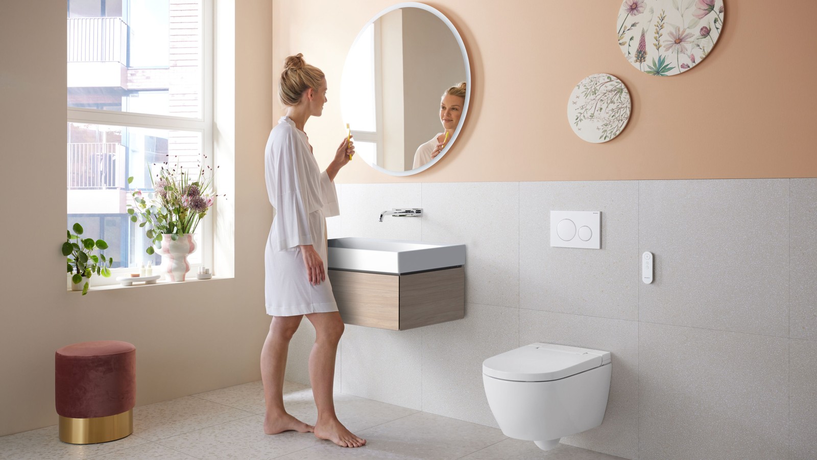 Woman in bathroom with Geberit AquaClean Alba - a cost-effective bidet toilet spray functionality Woman in bathroom with Geberit AquaClean Alba - a cost-effective bidet toilet spray functionality
