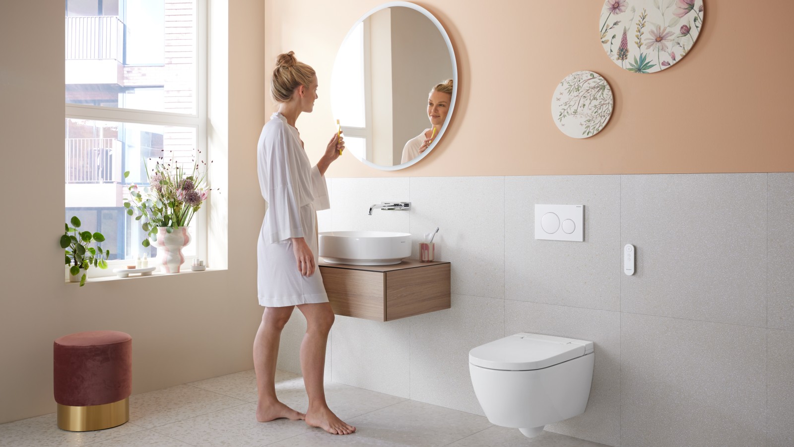 Woman in bathroom with Geberit AquaClean Alba - a cost-effective bidet toilet spray functionality Woman in bathroom with Geberit AquaClean Alba - a cost-effective bidet toilet spray functionality