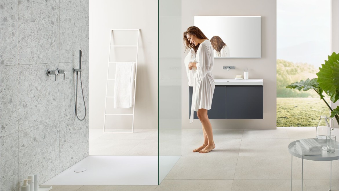 Woman standing in a bathroom with a walk-in shower Woman standing in a bathroom with a walk-in shower