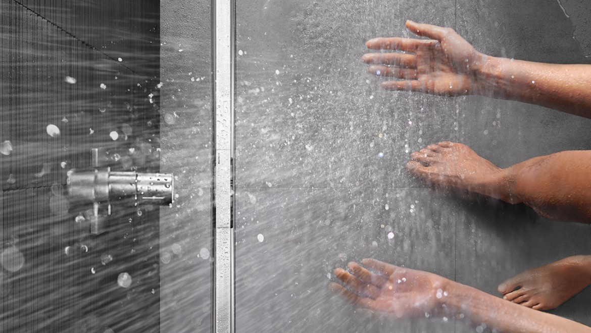Person showering in a floor-even shower with Geberit CleanLine shower channel