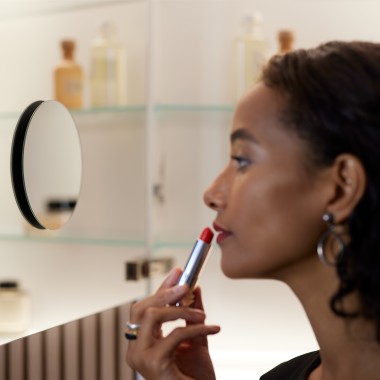 Woman applying make-up in the mirror Woman applying make-up in the mirror