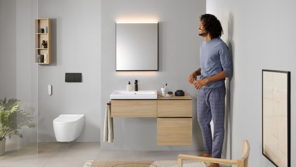 Man standing in the bathroom with an AquaClean Sela shower toilet Man standing in the bathroom with an AquaClean Sela shower toilet