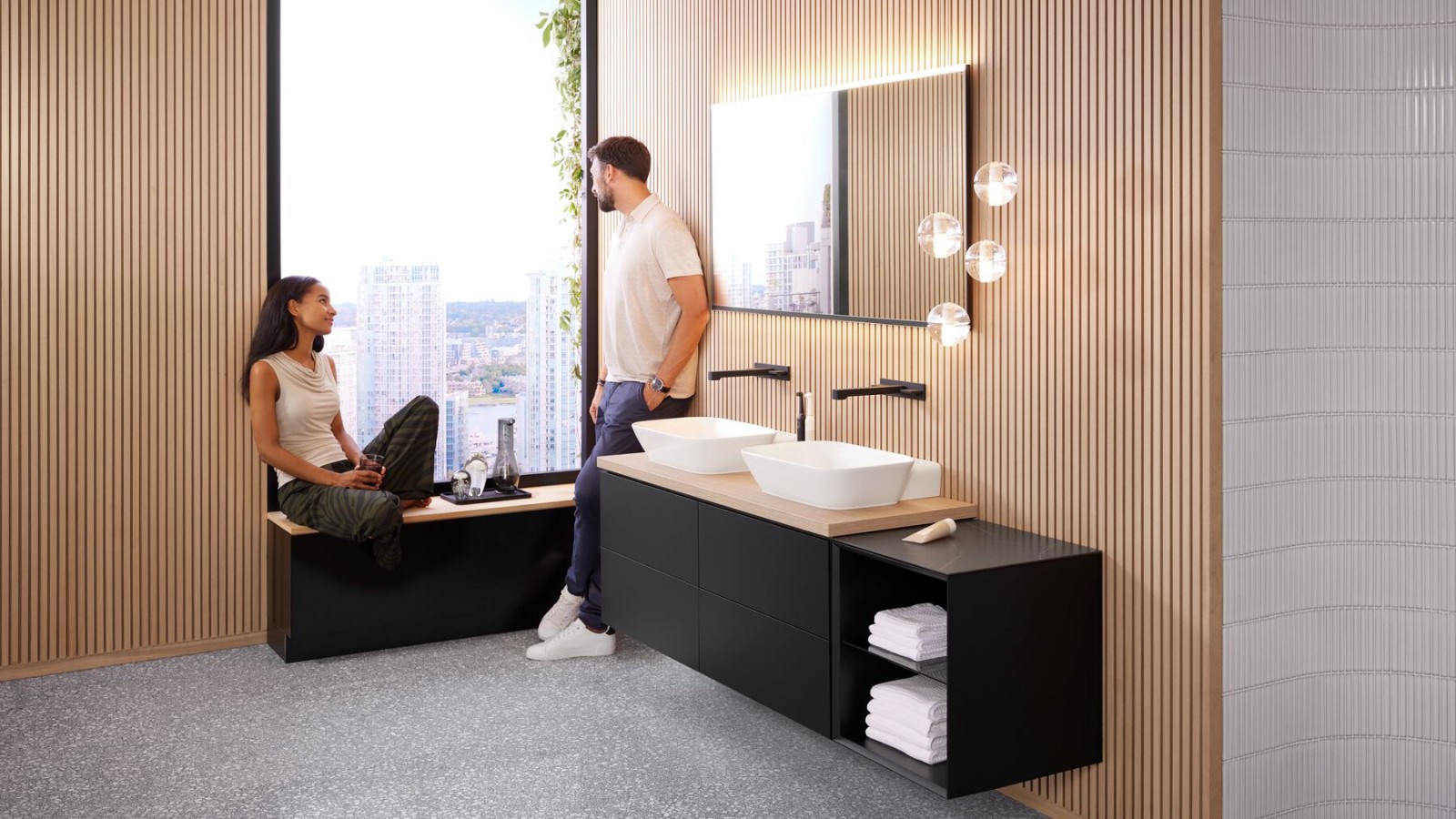 A woman and a man in a large bathroom with Geberit ONE double washbasin, Option mirror and wood elements A woman and a man in a large bathroom with Geberit ONE double washbasin, Option mirror and wood elements
