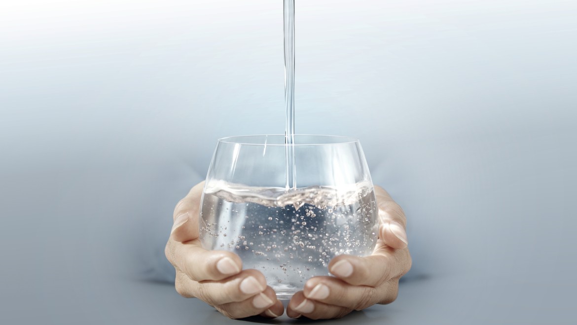 Person holding a glass of water in their hands