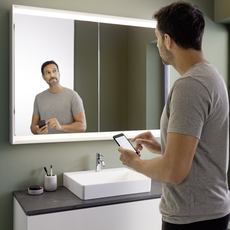 Man controls lighting of the Geberit ONE mirror cabinet with his smartphone (© Geberit) Man controls lighting of the Geberit ONE mirror cabinet with his smartphone (© Geberit)