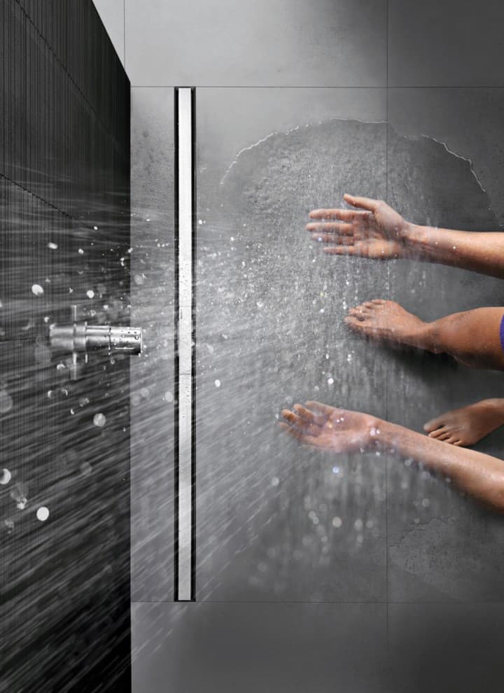Person showering in a floor-even shower with CleanLine Person showering in a floor-even shower with CleanLine