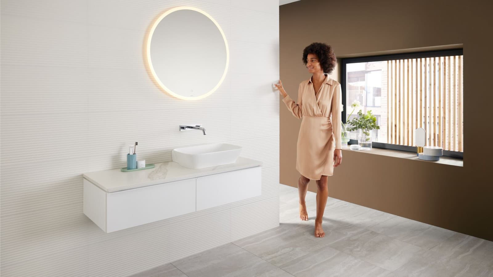 Woman in modern bathroom featuring a brown colour scheme - the latest bathroom colour trend - and a Mix & Match washbasin area combination Woman in modern bathroom featuring a brown colour scheme - the latest bathroom colour trend - and a Mix & Match washbasin area combination